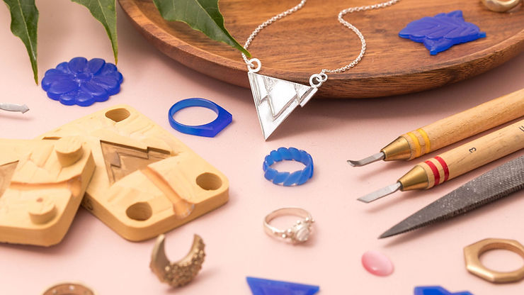 Silver necklace surrounded by jewellery making tools and moulds