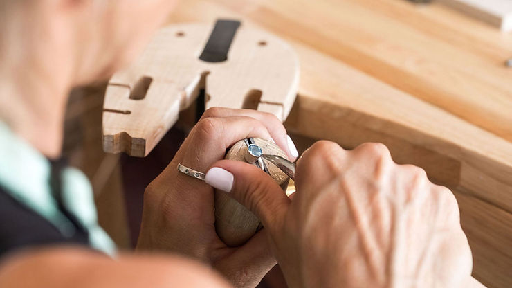 Someone adding a stone to a ring