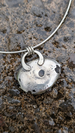 Pebble necklace pendant on rock