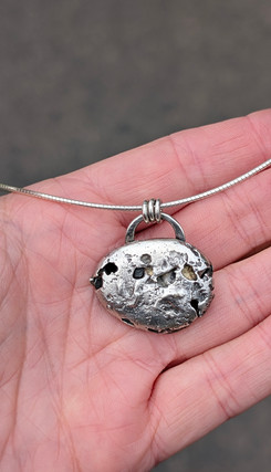 Pebble necklace pendant in open hand